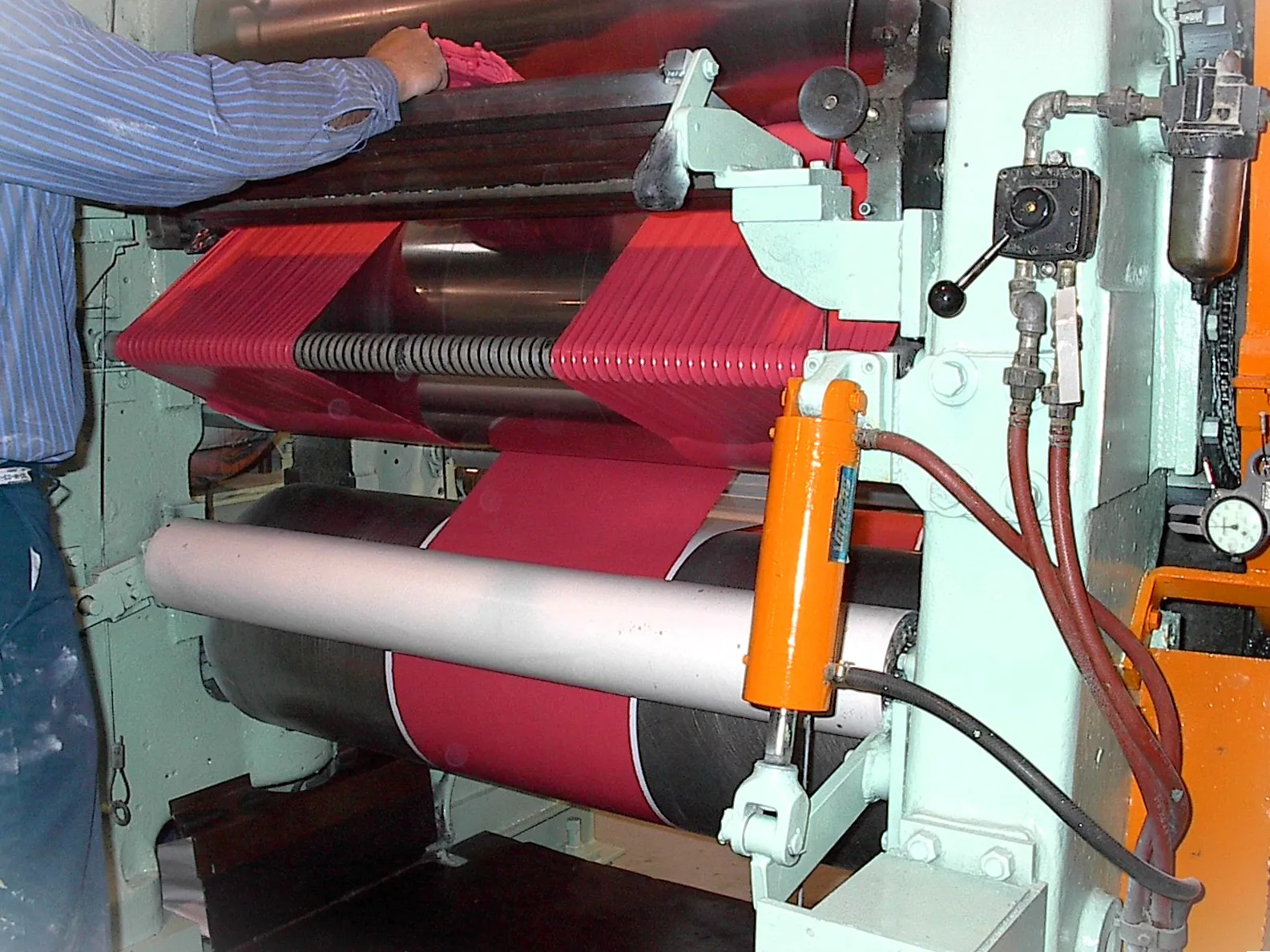 Red sheet rubber running through the rolls of the 54-inch calender